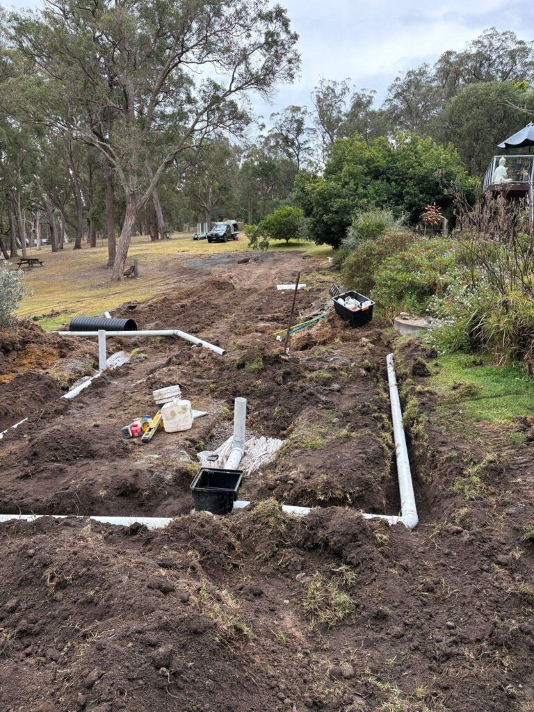 Excavated septic drain field run beside a rural house before reinstatement, Kanoona NSW