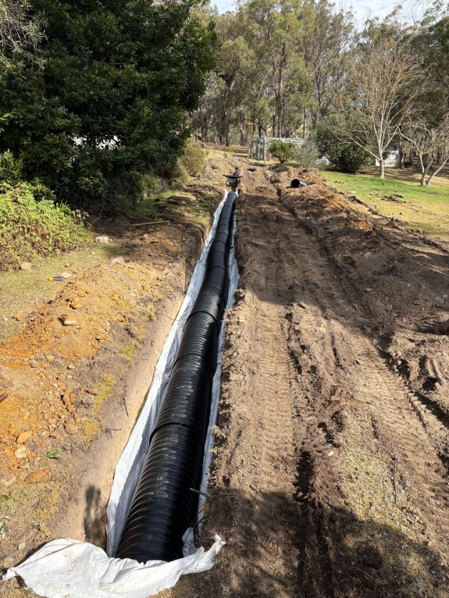 New gravity soakage trench before backfill on a rural property near Bega